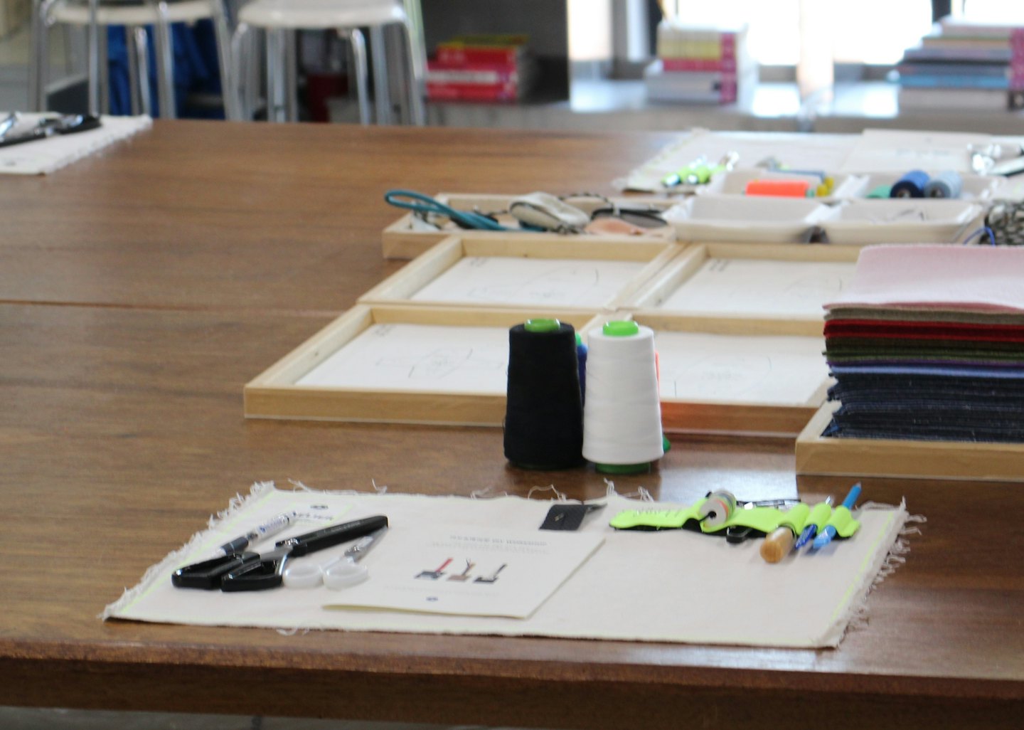 Crafting and sewing supplies arranged on a wooden workshop table.