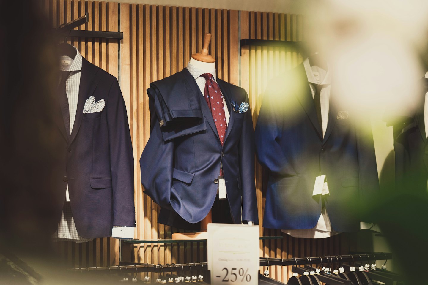 Mannequins in blue suits displayed in a menswear store.